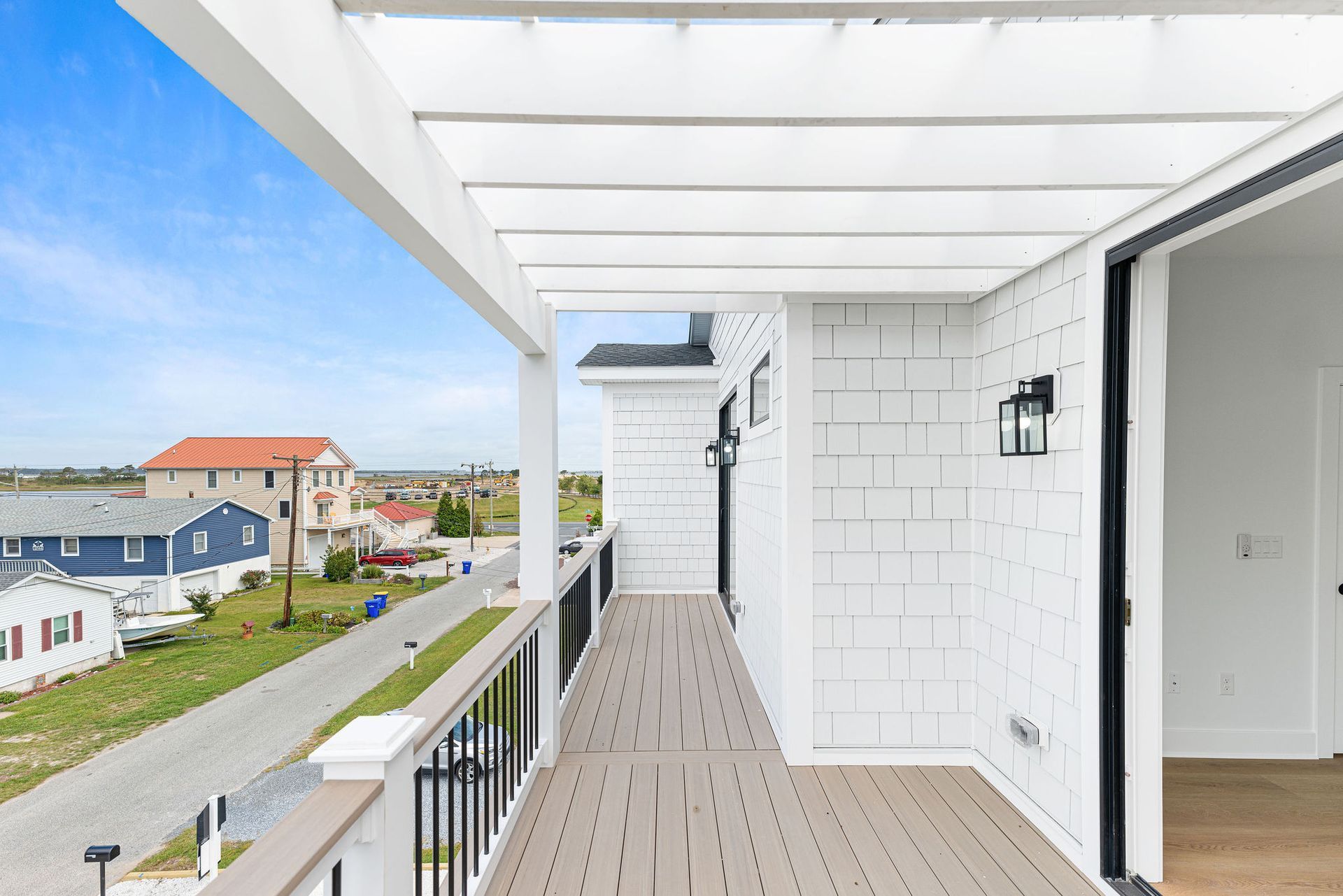 A balcony with a view of a street and a house.