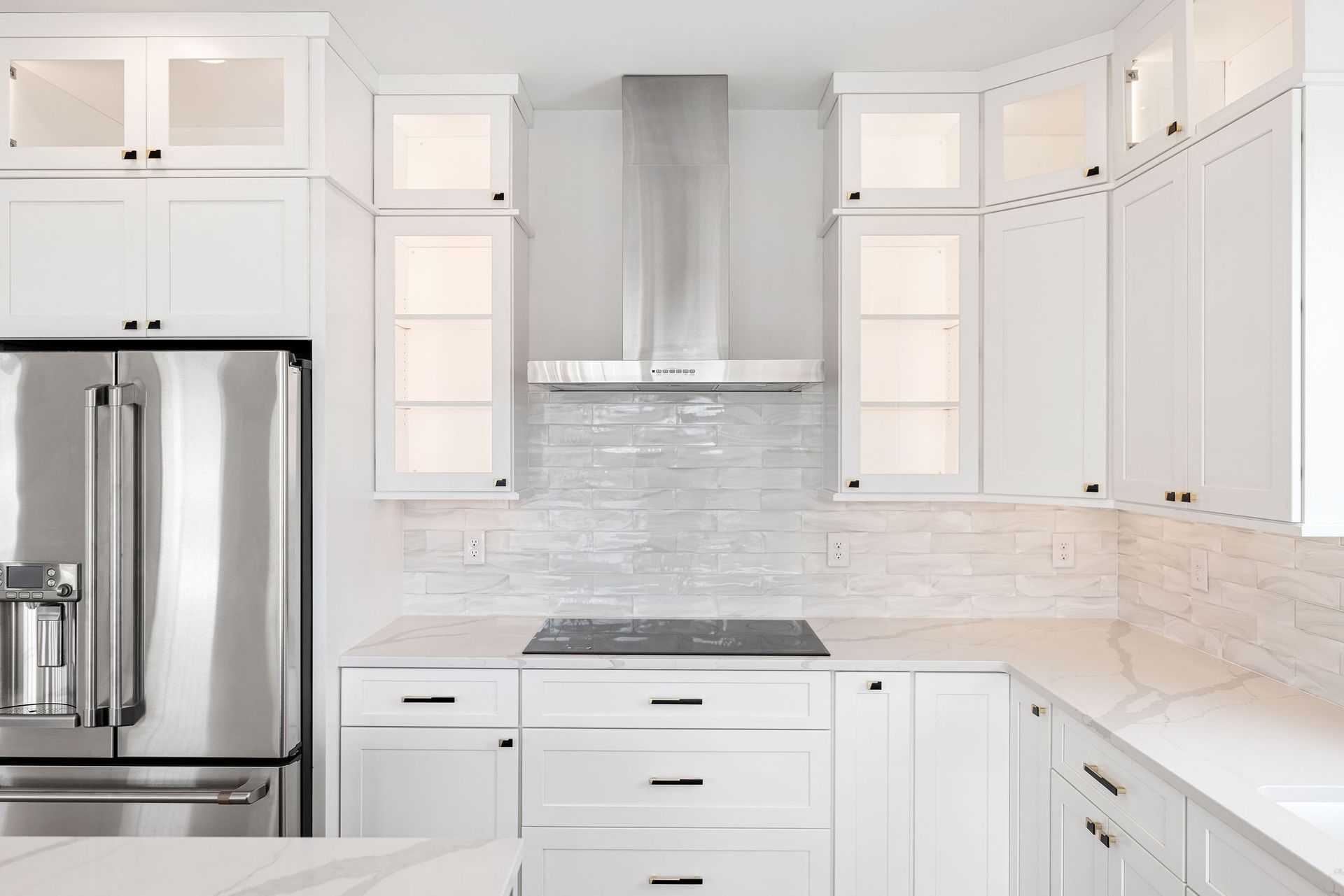 A kitchen with white cabinets and stainless steel appliances.