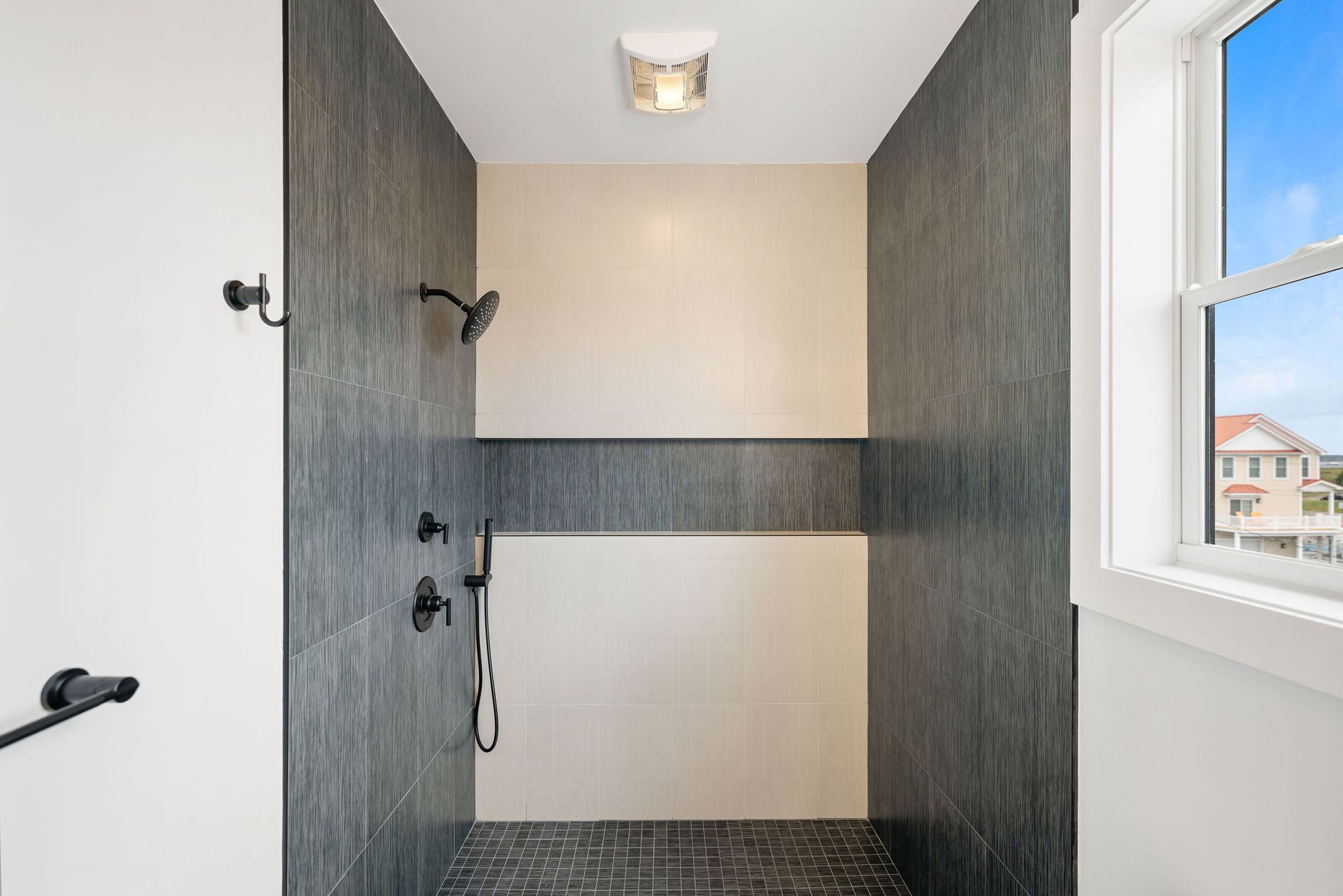 A bathroom with a walk in shower and a window.