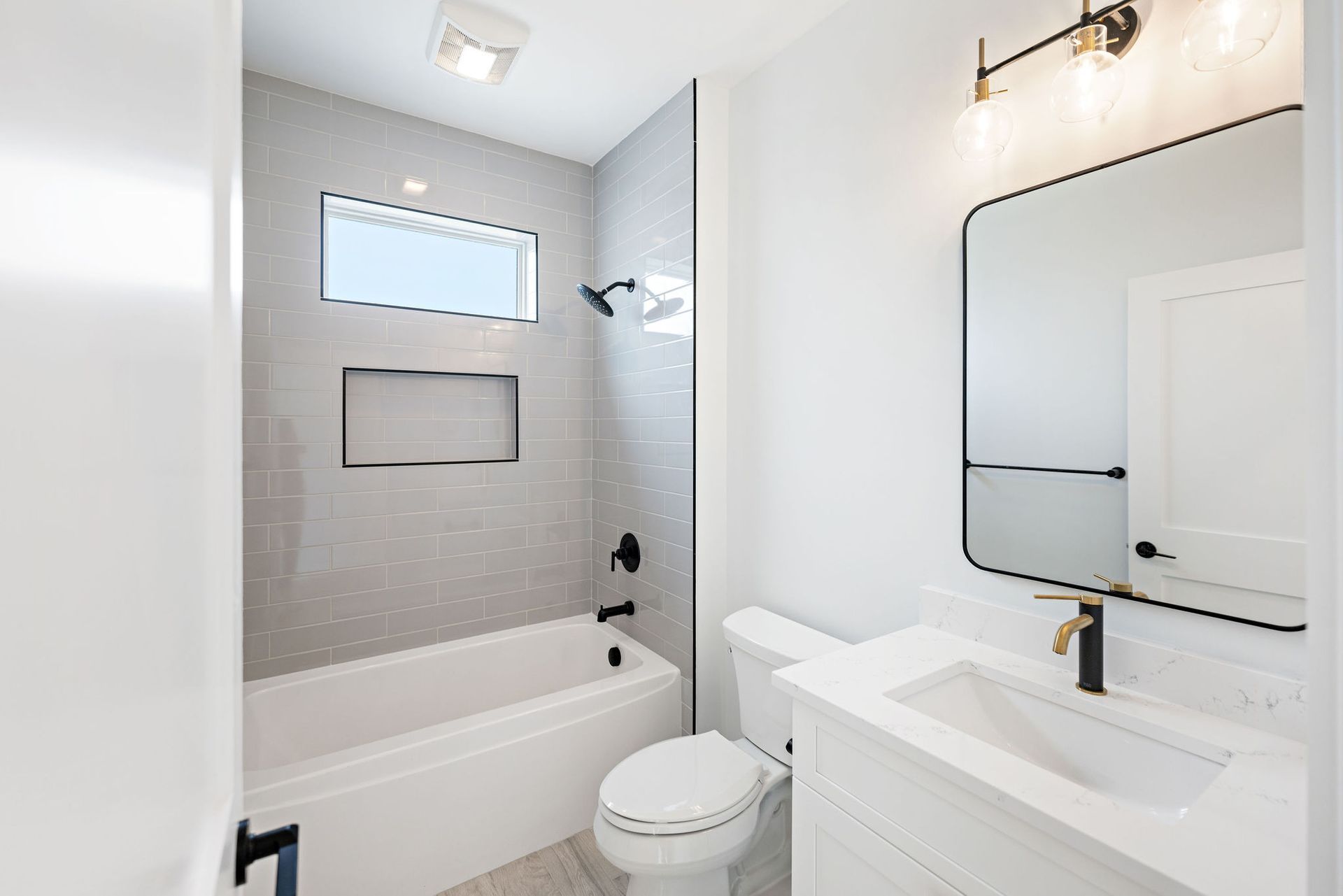 A bathroom with a toilet, sink, and bathtub.