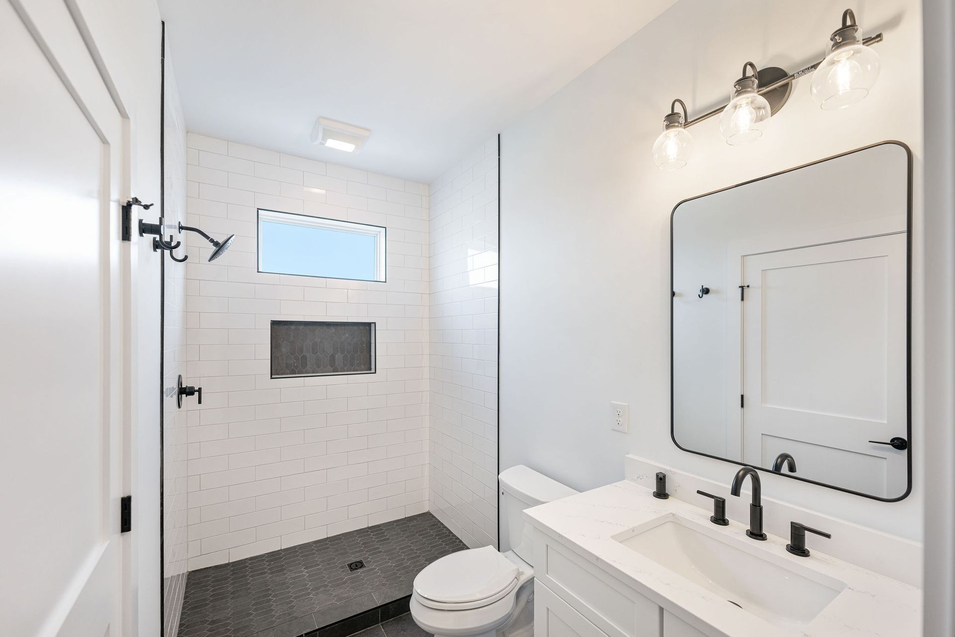 A bathroom with a toilet, sink, and shower.