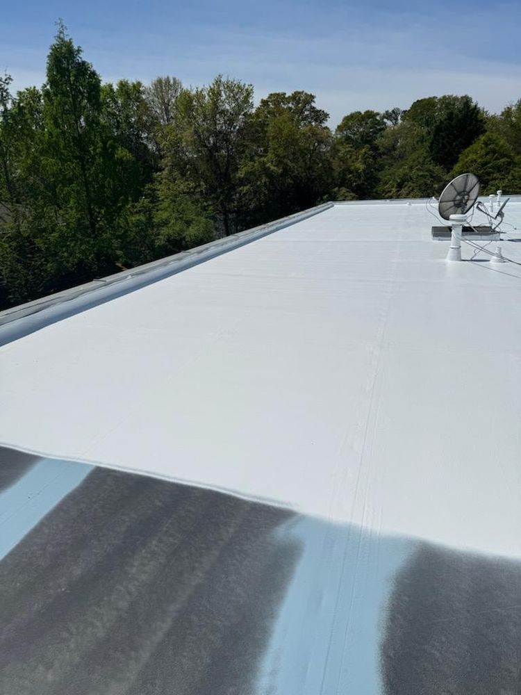 White flat roof with trees in background and a satellite dish.