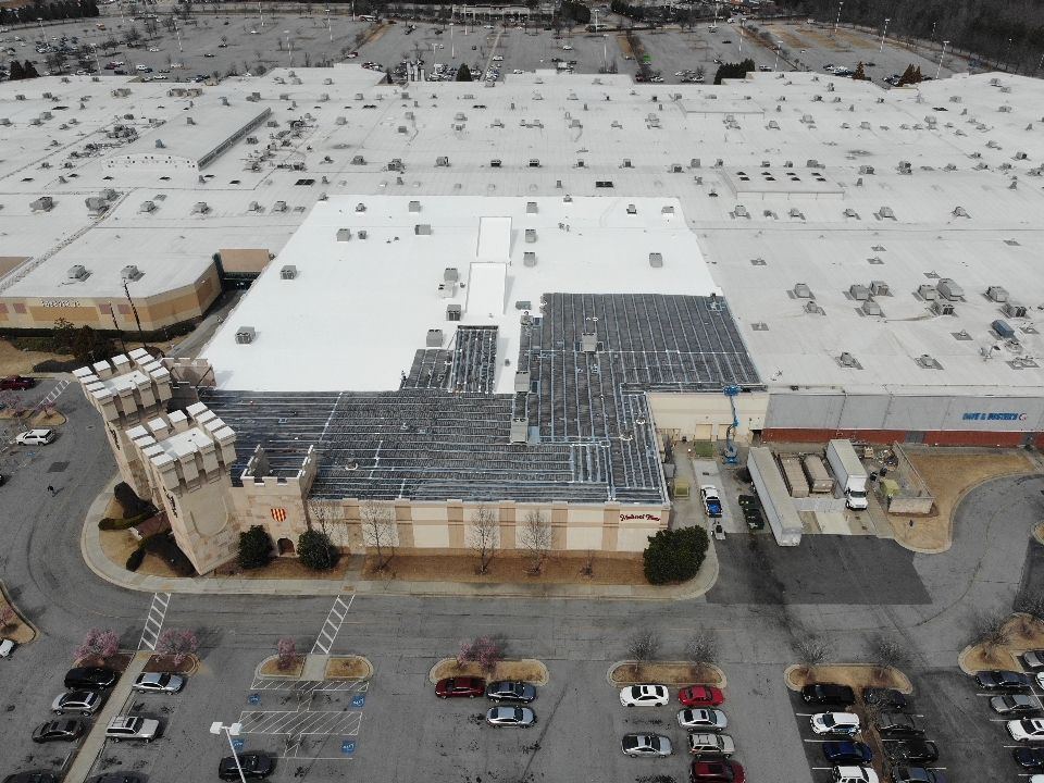 Aerial view of a shopping center with a castle-themed building and large parking lot.
