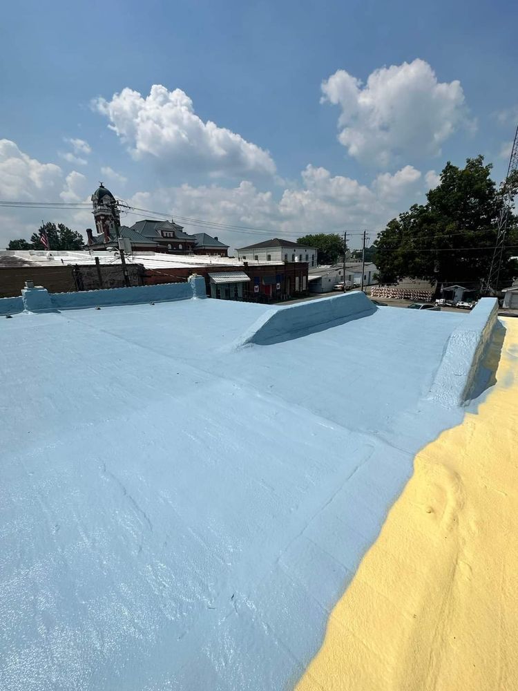 Blue and yellow painted rooftop with buildings and blue sky in the background.