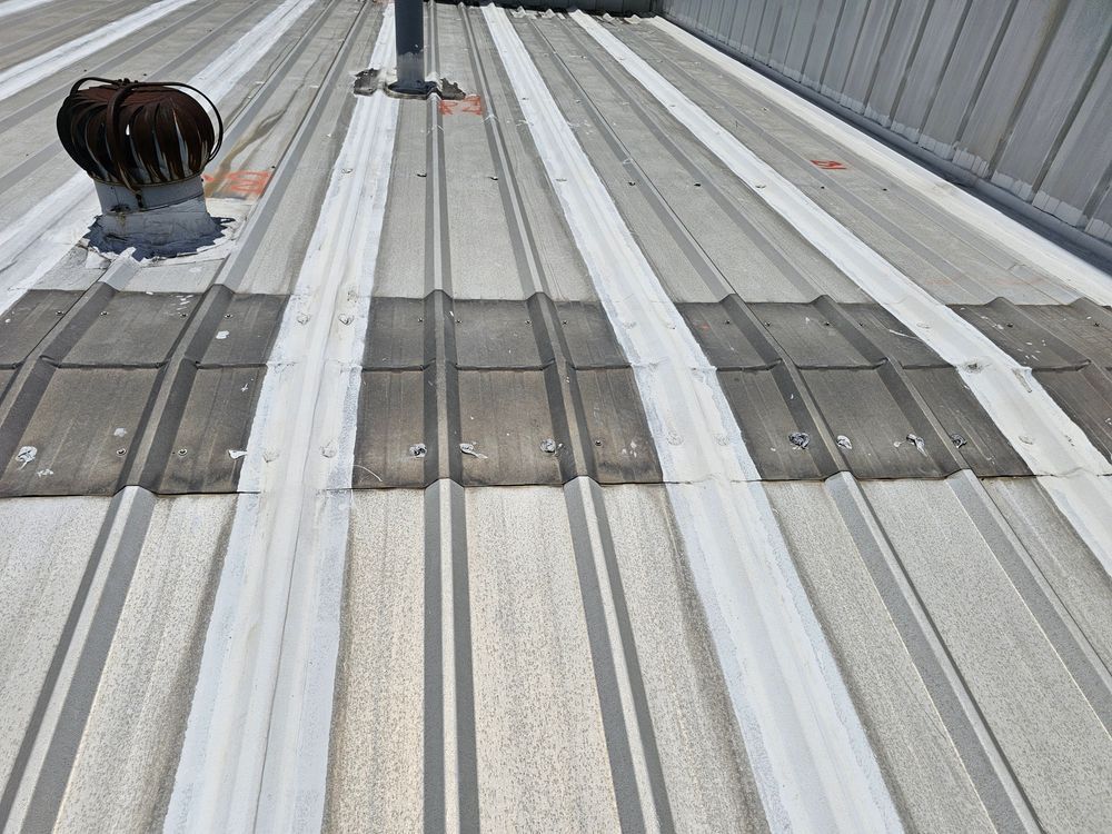 Metal roof with visible ridges, a vent, and a light-colored surface.