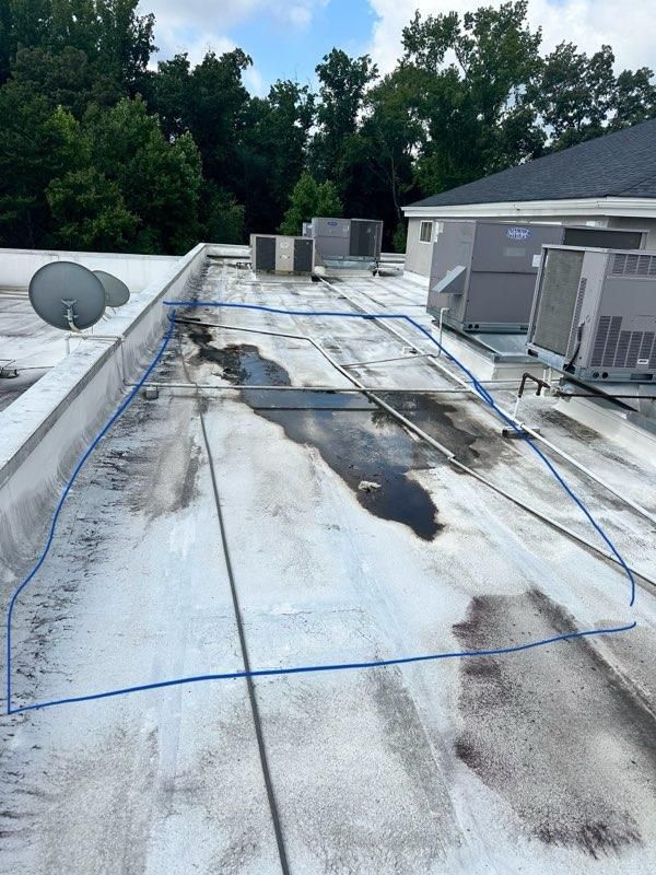 Flat commercial roof with air conditioning units and a satellite dish. Wet area outlined in blue.