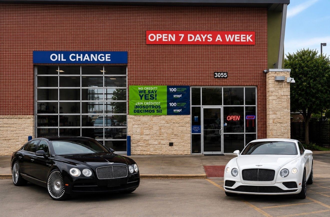 Two cars parked outside an auto shop with “Oil Change” and “Open 7 Days a Week” signs