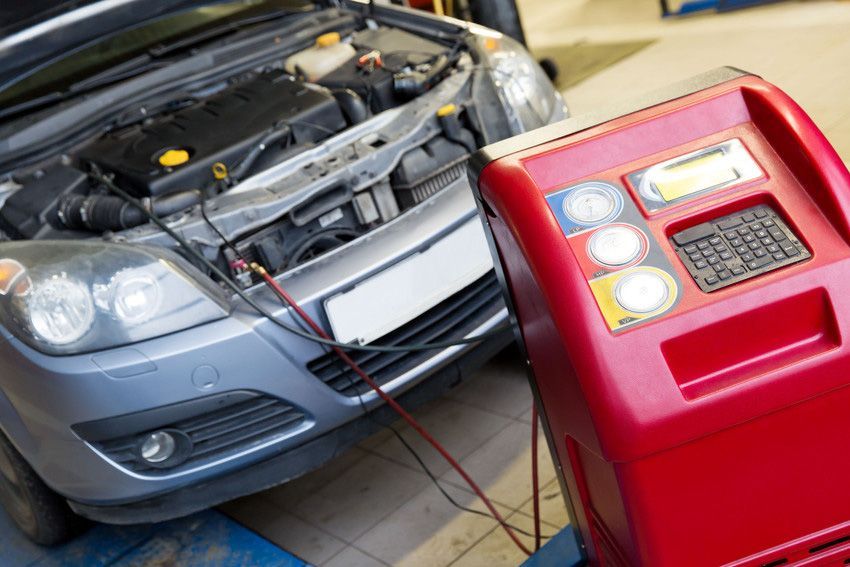 A car is being serviced by a mechanic in a garage.