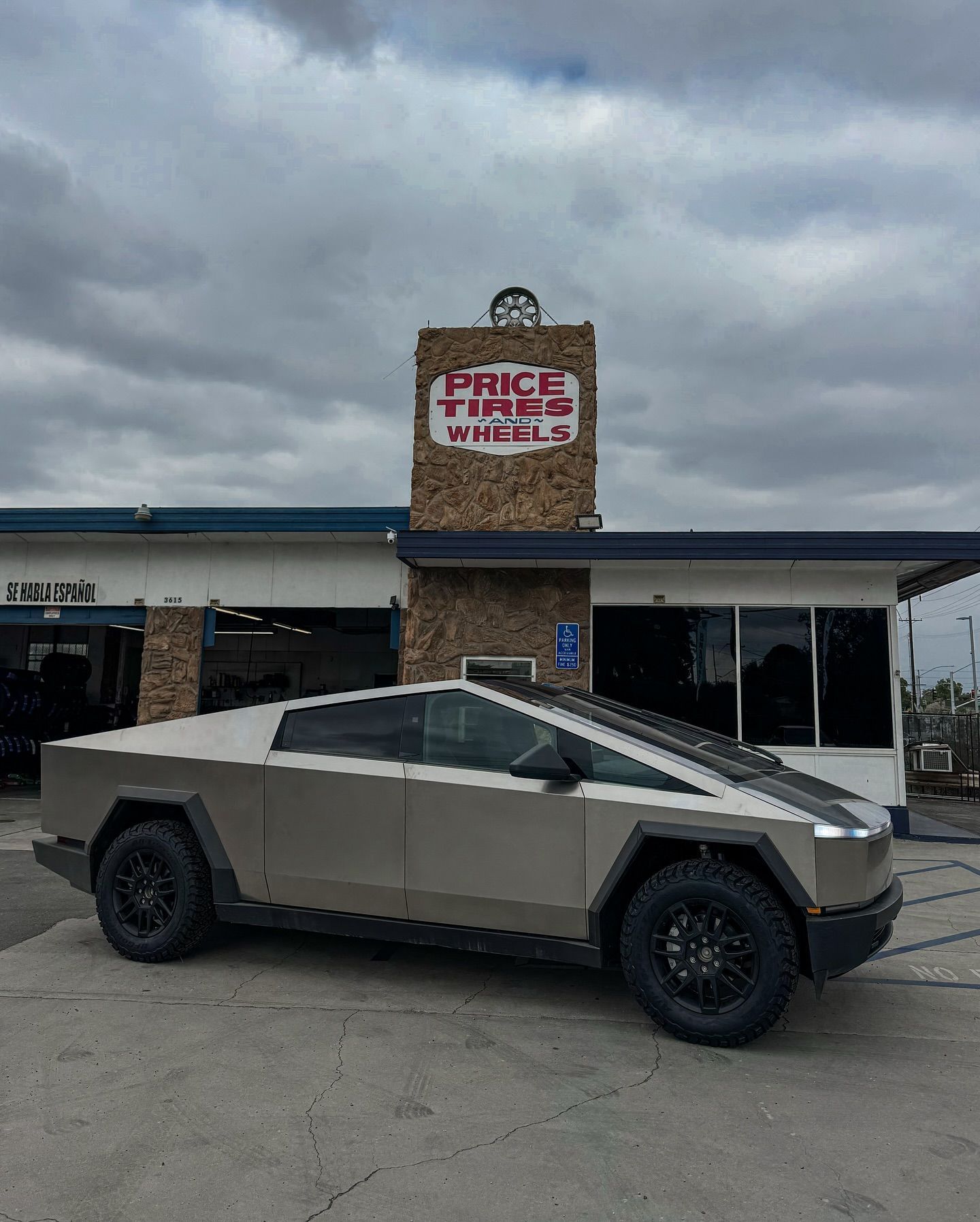 A silver Tesla Cybertruck parked in front of a stone building with a 