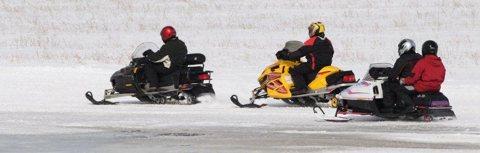 People riding on their snowmobile