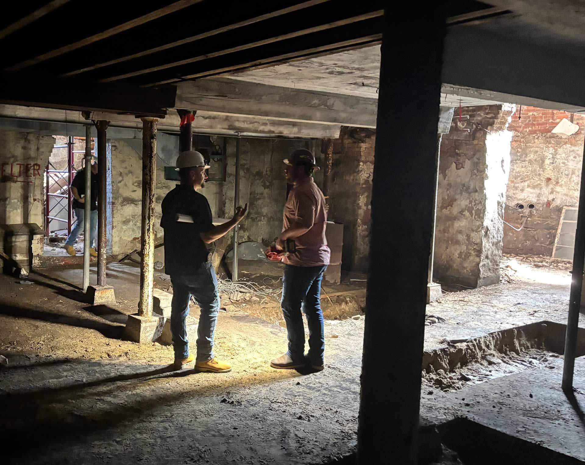 two men are standing in a construction site talking to each other