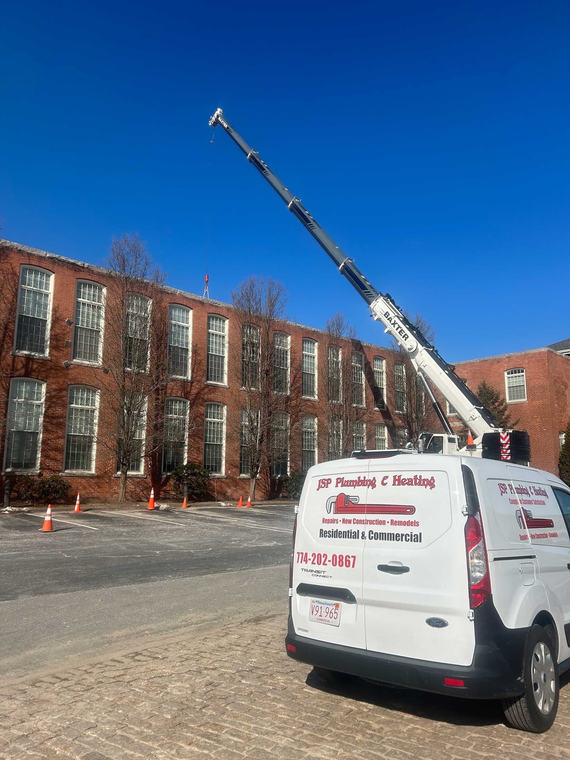 a white van with a crane on the back is parked in front of a brick building