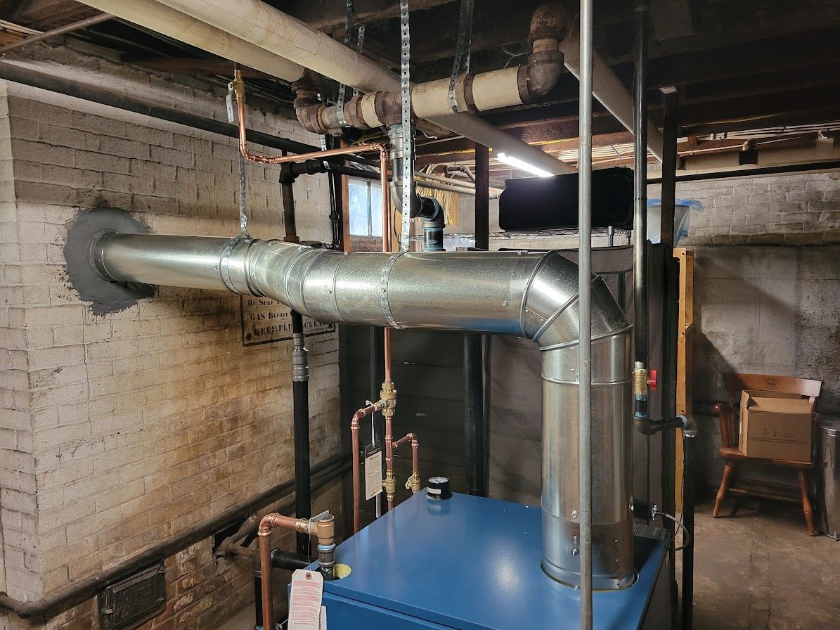 a blue boiler is sitting in a basement next to a brick wall
