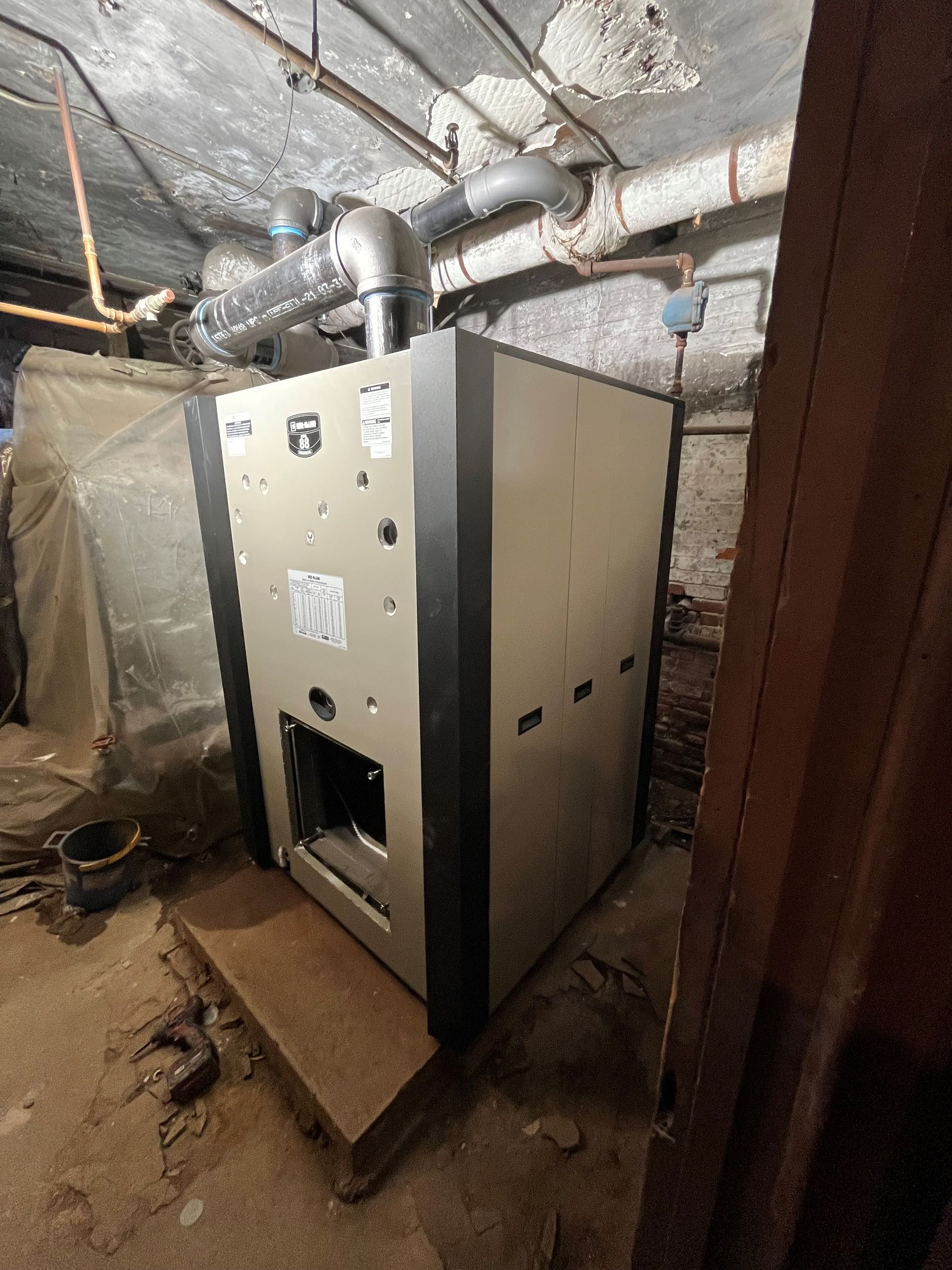 a large boiler is sitting in a basement next to a door