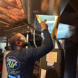 Technician inspecting an air duct system.