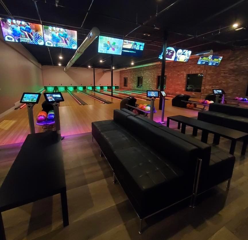 A bowling alley with a lot of tables and chairs