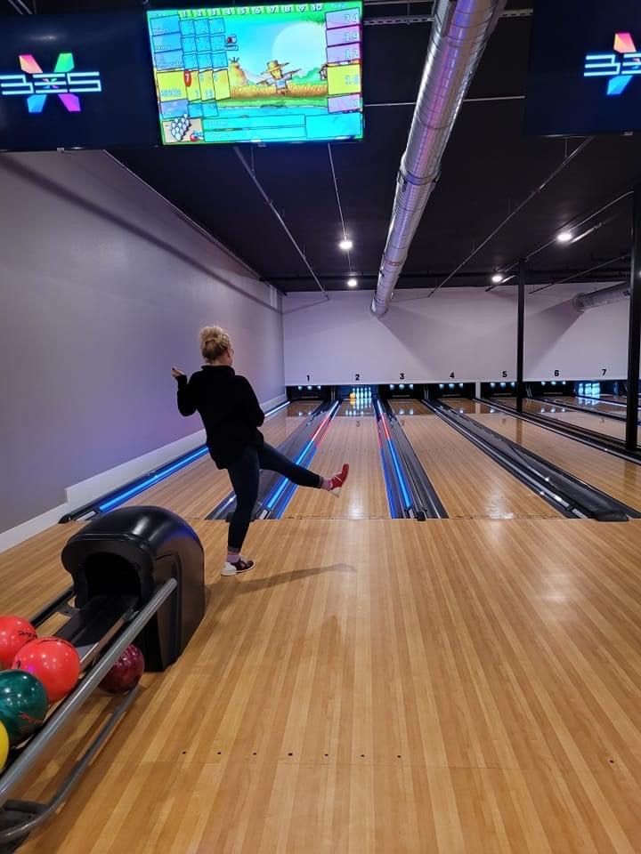 A woman is throwing a bowling ball on a bowling alley