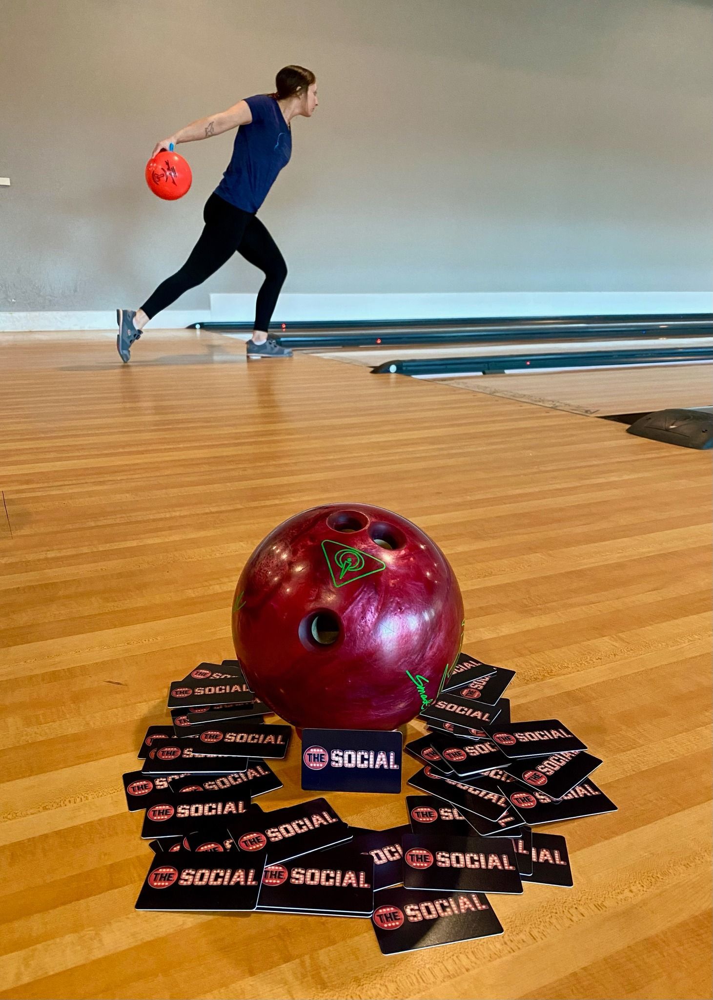 A woman is throwing a bowling ball in a bowling alley.