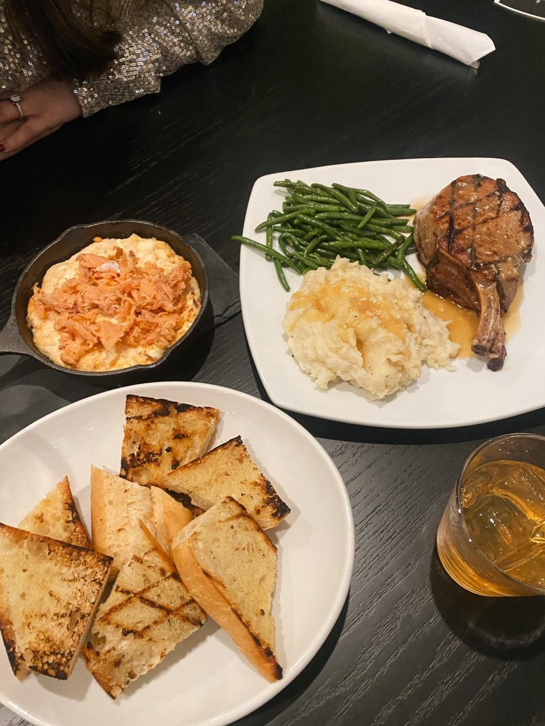 A table topped with plates of food and a glass of beer