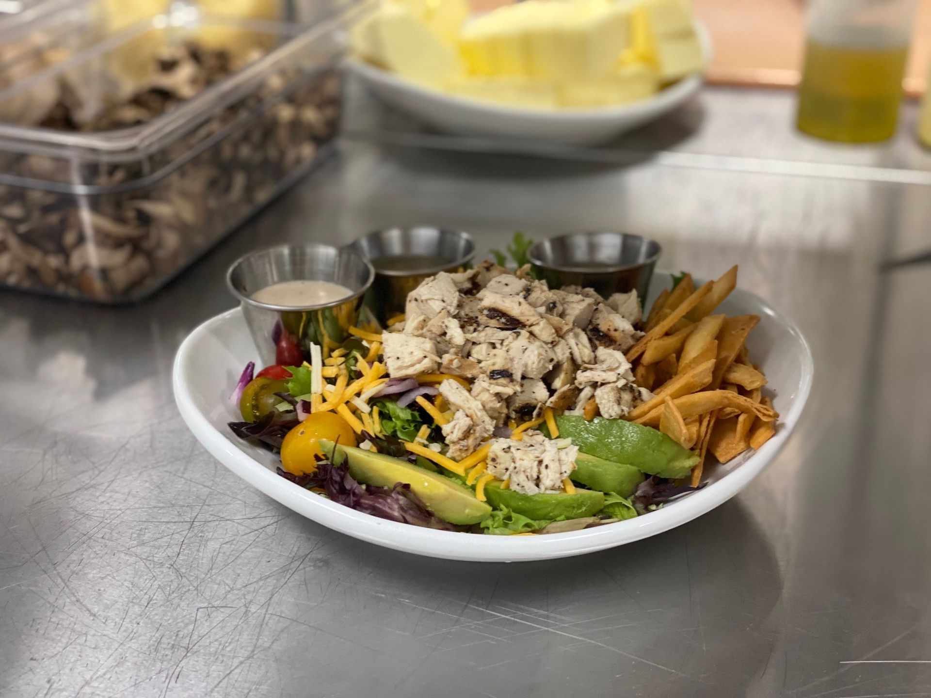 A white plate topped with a salad and french fries on a table.