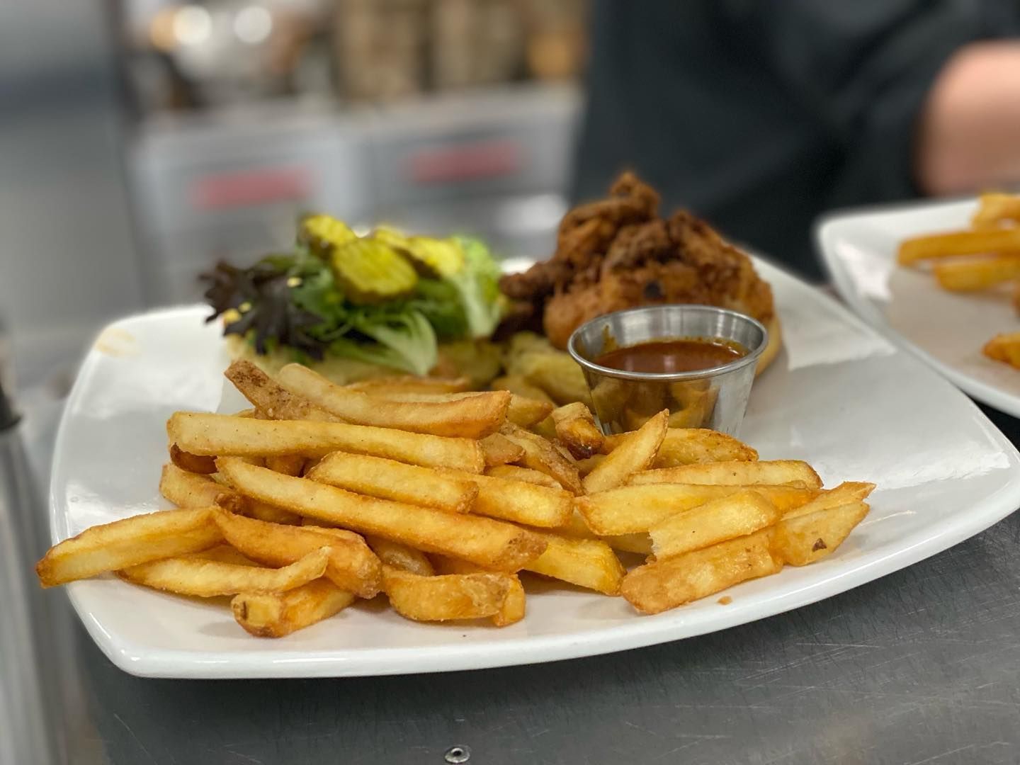 A white plate topped with french fries and a sandwich.