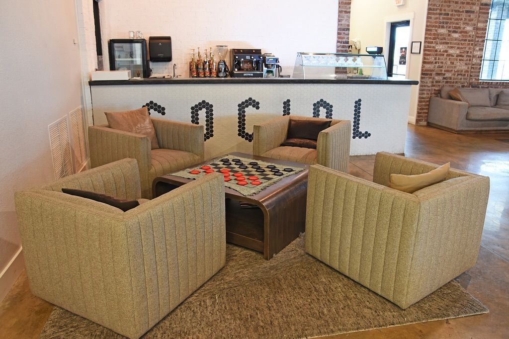 A living room with chairs and a table with the word social on the wall