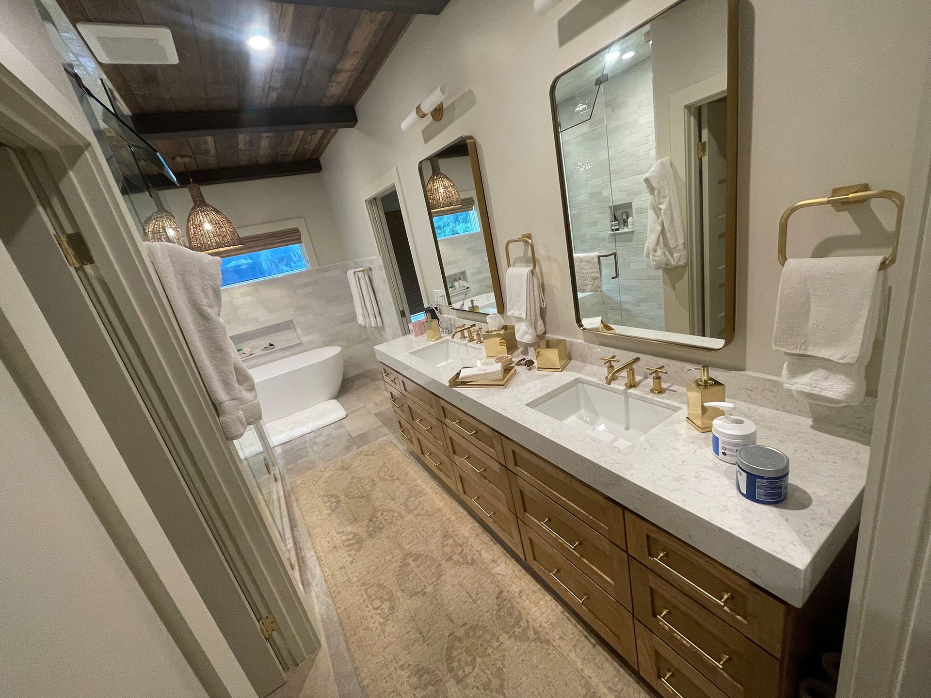 A bathroom with two sinks , two mirrors and a bathtub.