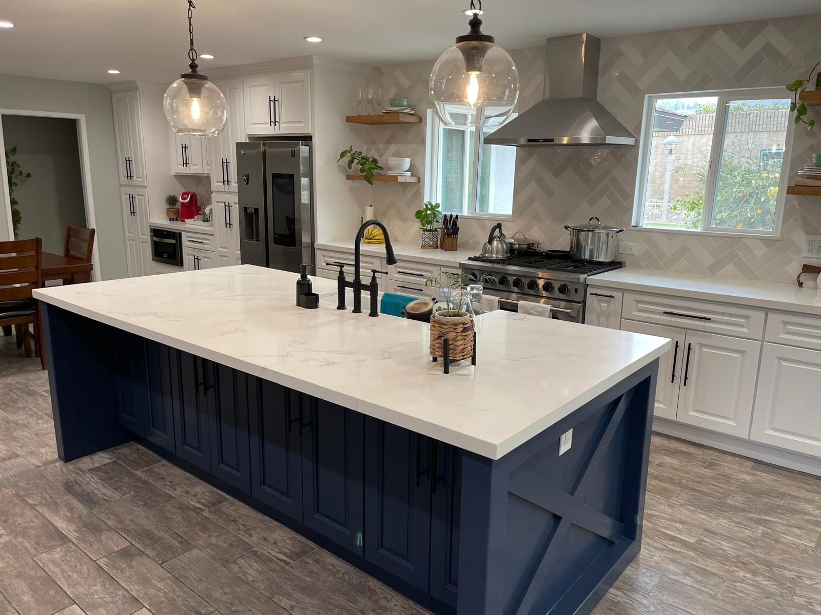 A kitchen with a large island and white countertop.