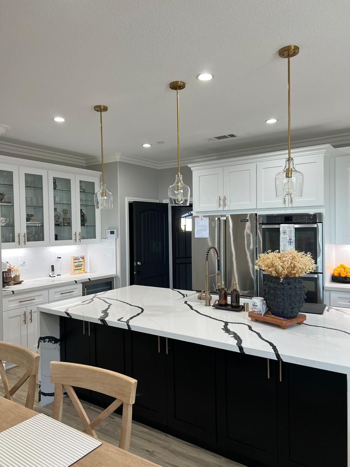A kitchen with white cabinets and a large island