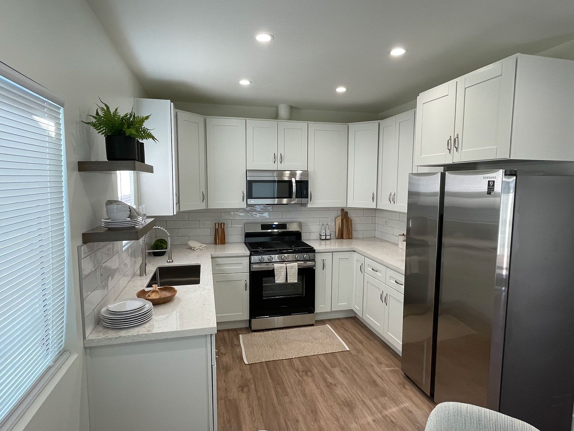 A kitchen with white cabinets and stainless steel appliances