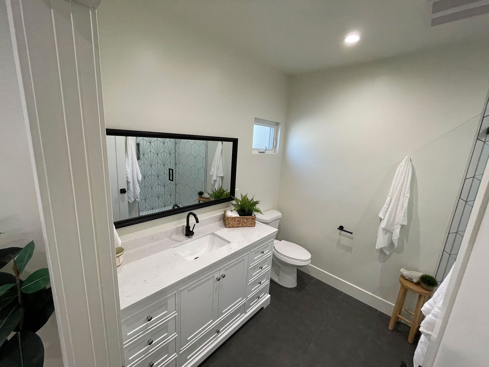A bathroom with a sink, toilet, and mirror