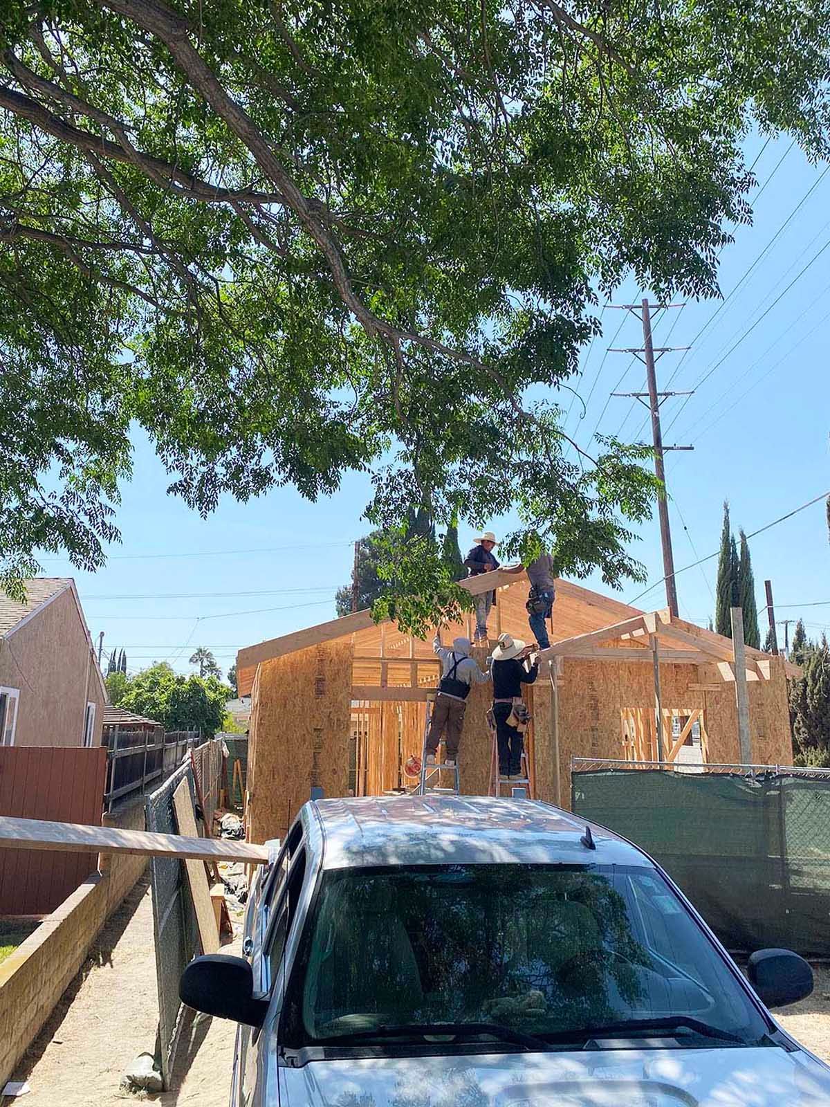 A car is parked in front of a house under construction