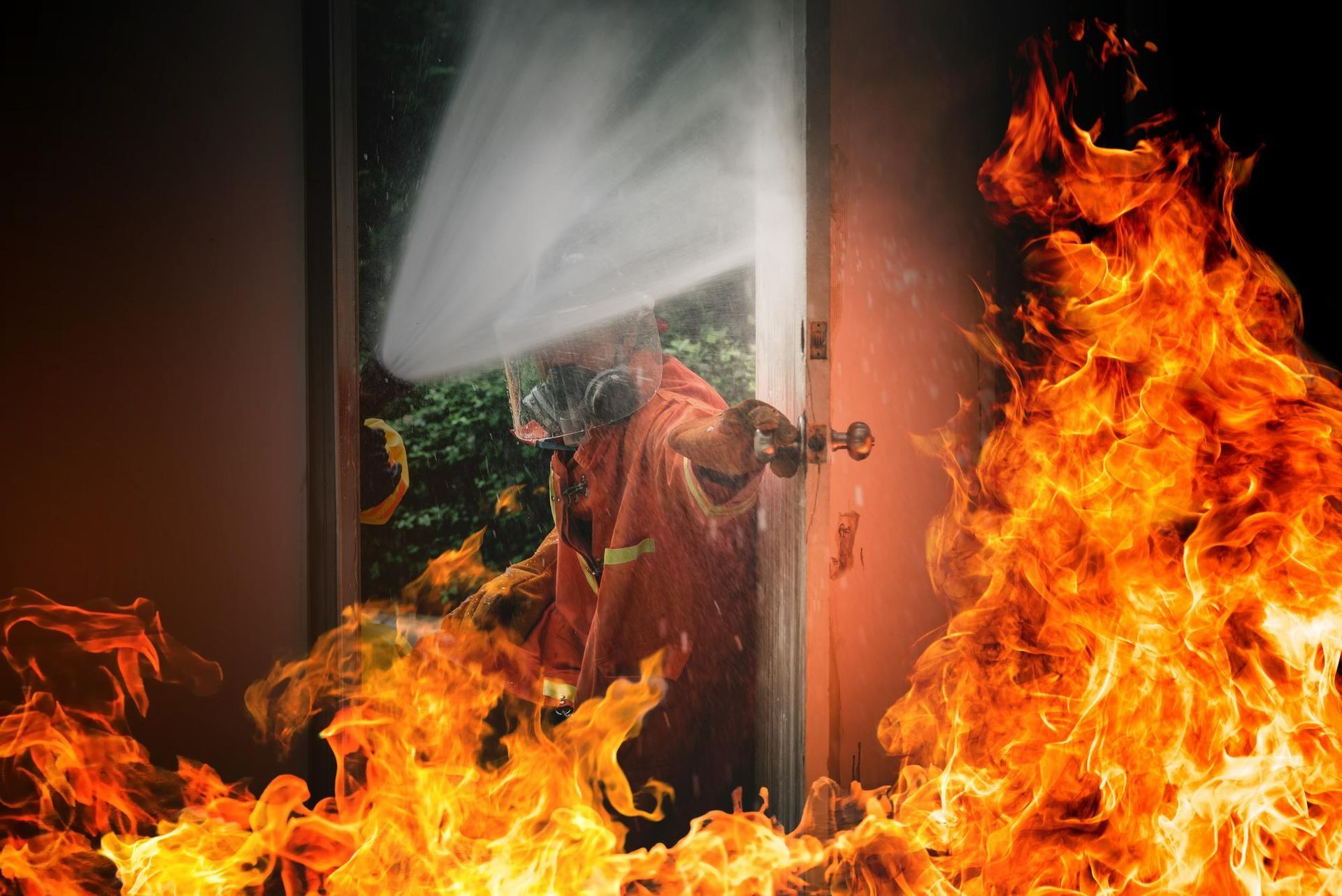 Person in a doorway amid flames and smoke, with fire blazing in the foreground and right side