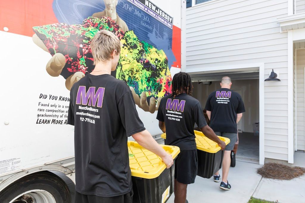 People carrying yellow bins past a colorful wall mural outside a building