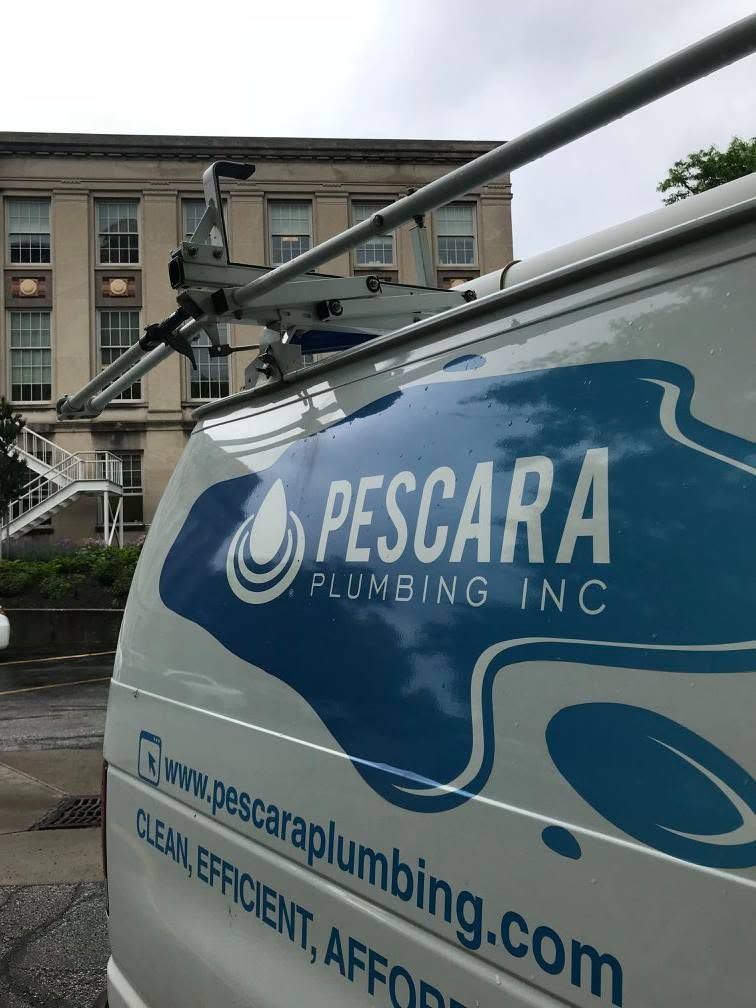 Blue Pescara Plumbing van parked by a building, with company logo and website visible