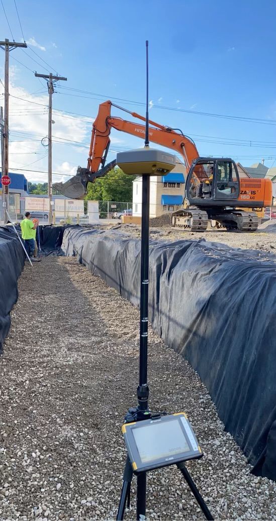 A construction site with a large excavator in the background.