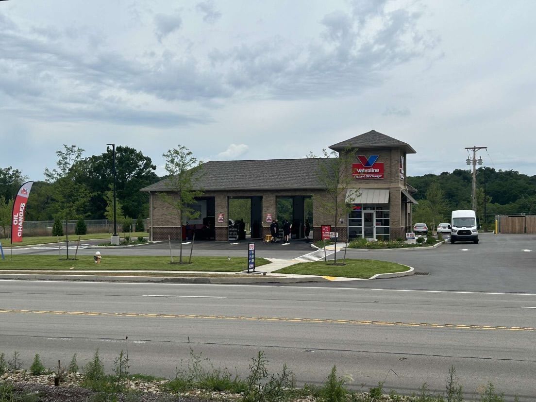 A car wash is located on the side of the road next to a parking lot.