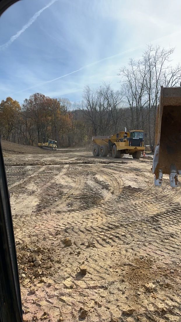 A bulldozer is driving through a dirt field.