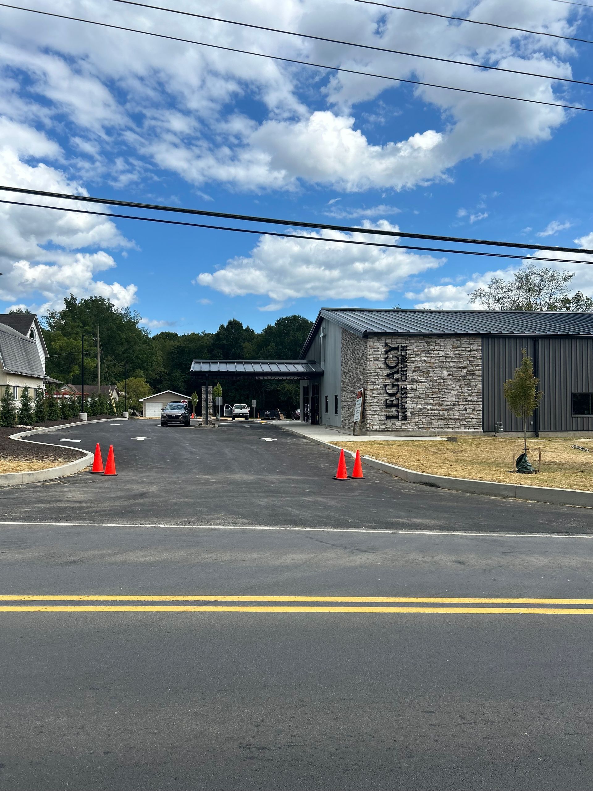 A car is parked on the side of the road in front of a building