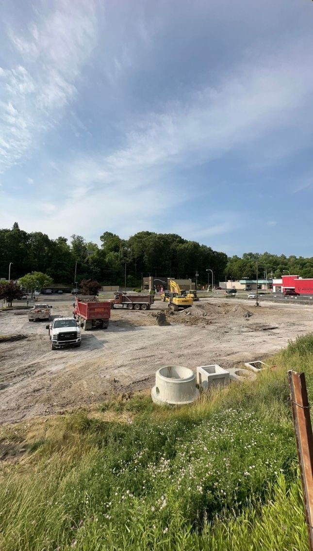 A large construction site with a lot of trucks and tractors.