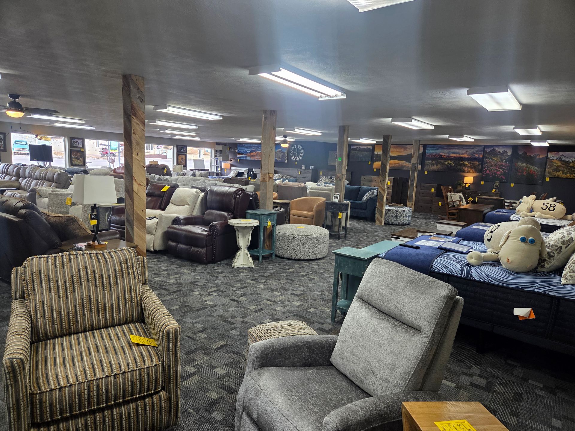 Furniture showroom with various couches, chairs, and tables on display.
