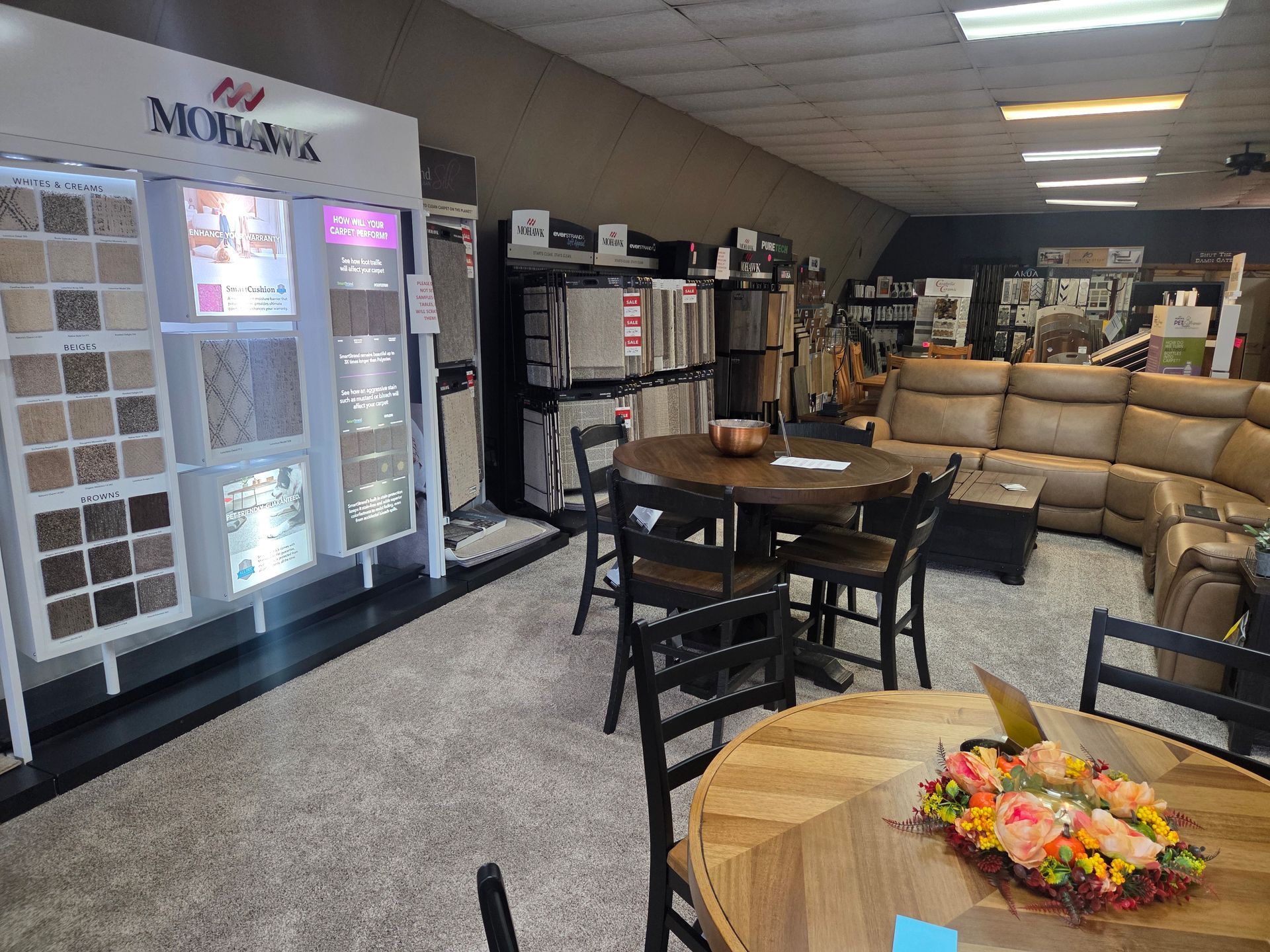 Interior of a flooring showroom with tile samples, furniture, and seating.
