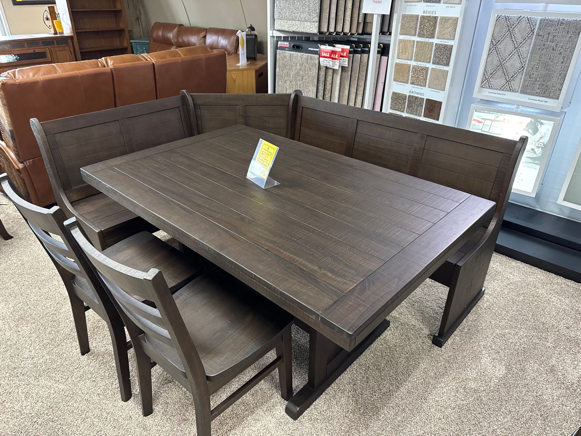 Dining set with a dark wooden table, benches, and chairs in a store.