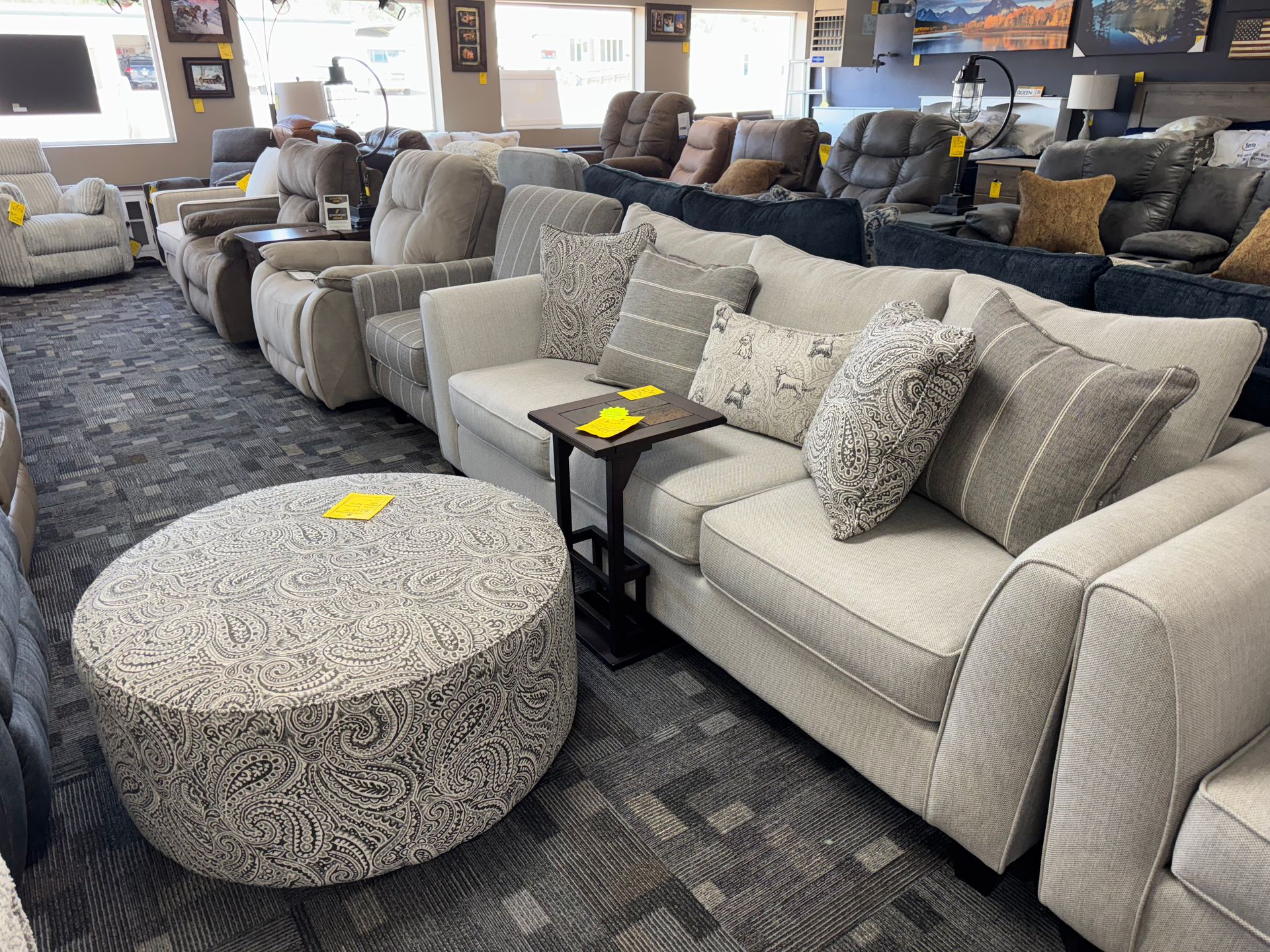 Furniture showroom with couches and an ottoman.