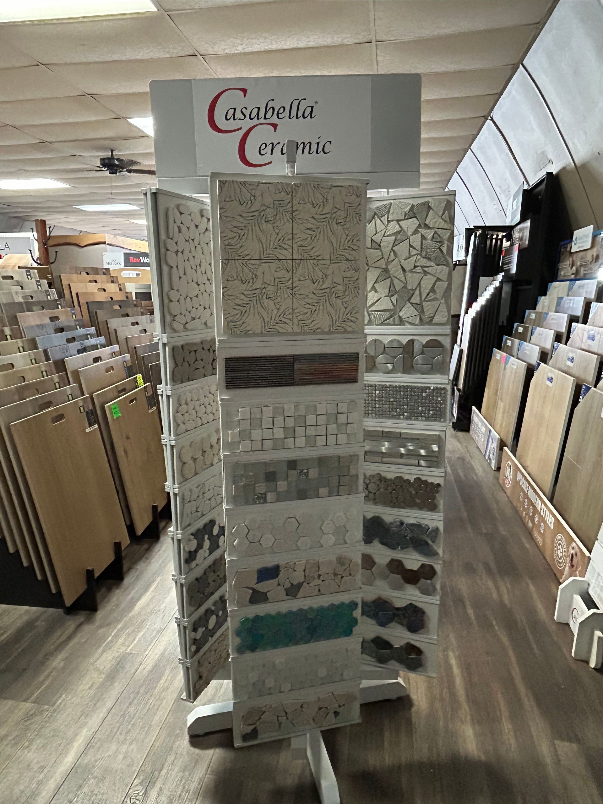 Tile display stand in a store, showcasing various tile samples.