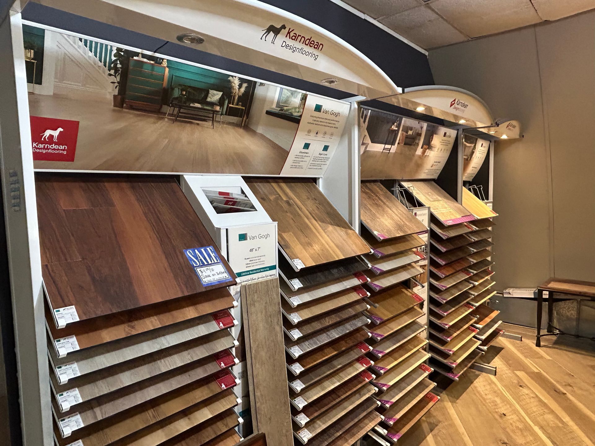 Display of hardwood flooring samples in a store, showcasing different wood tones and textures.
