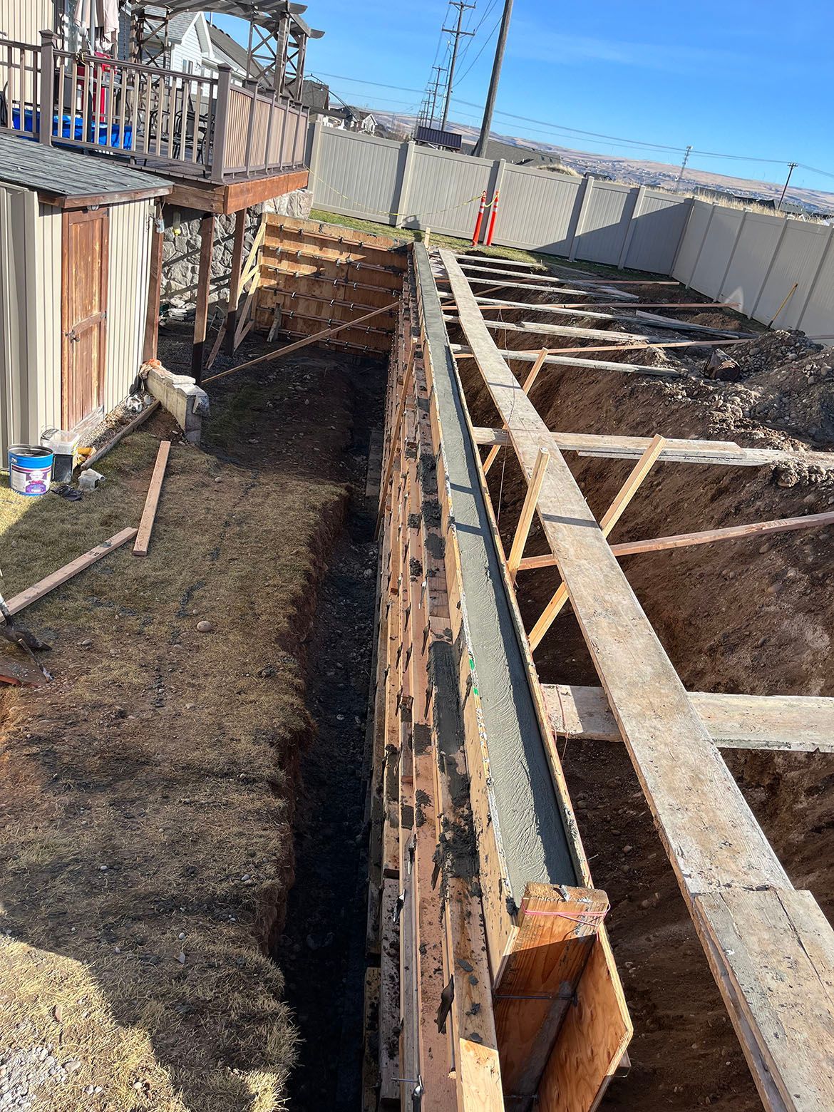 A concrete wall is being built next to a house.