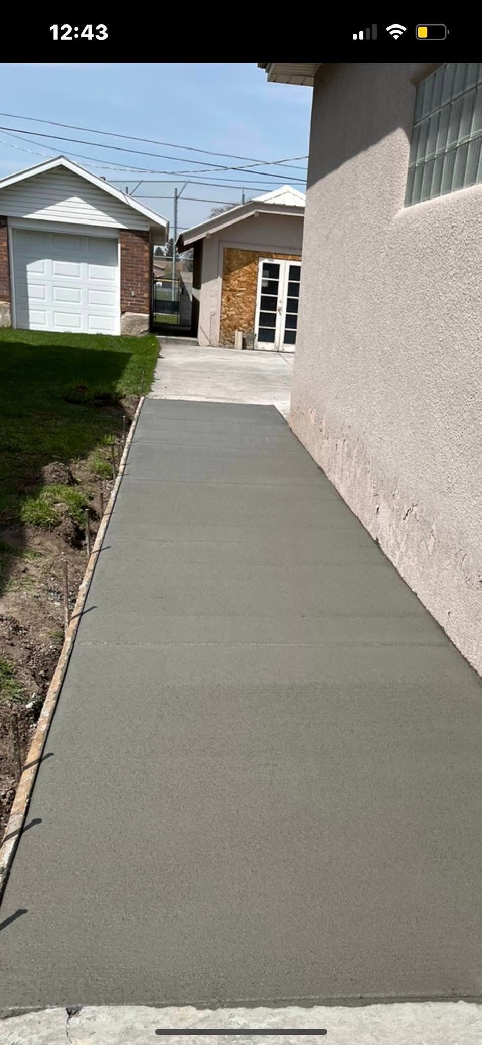 A concrete walkway is being built in front of a house