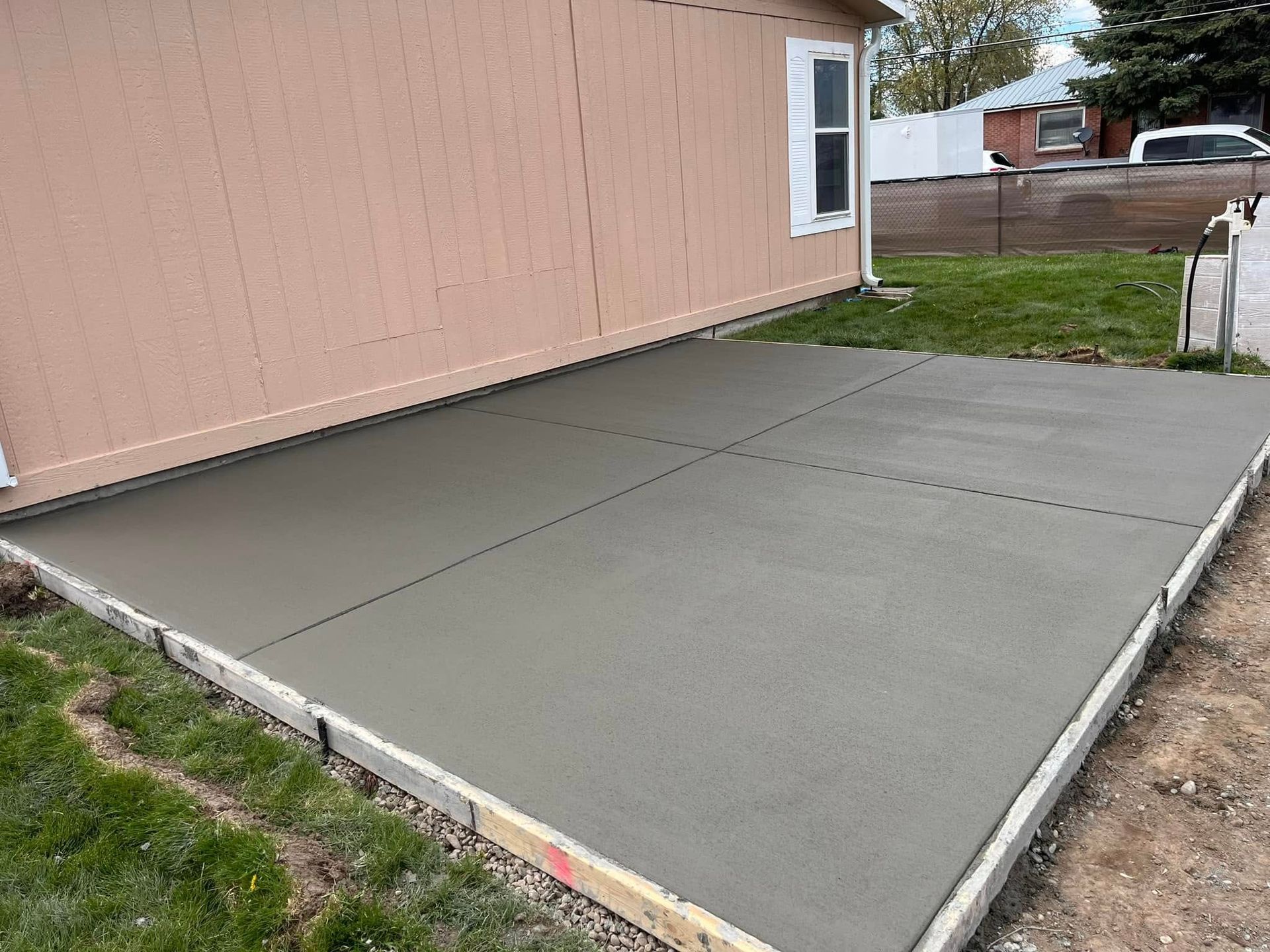 A concrete driveway is being built in front of a house