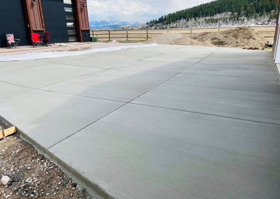 A concrete driveway is being built in front of a house